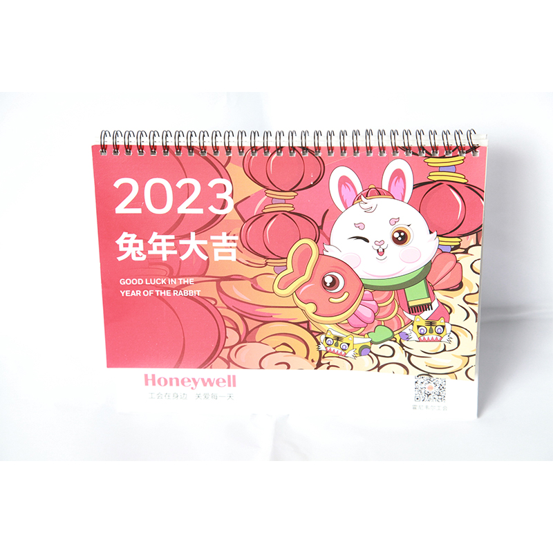 How does the choice of high-quality paper stock influence the durability and visual appeal of a wall calendar throughout the year?